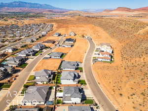 Aerial view of property and surrounding area featuring a mountain backdrop and nearby suburban area