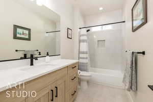 Full bath with vanity, shower / bath combo, light tile patterned floors, and recessed lighting