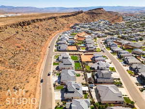Aerial view of property and surrounding area featuring nearby suburban area and a mountainous background