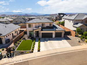 View of front of home featuring a residential view, driveway, stucco siding, and a mountain view
