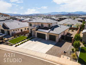 View of front of property featuring a residential view, stone siding, driveway, a standing seam roof, and a metal roof