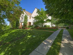 View of property hidden behind natural elements with a front yard