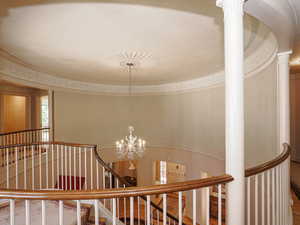 Staircase featuring a chandelier and wood finished floors