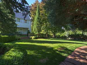 View of grassy yard featuring a porch