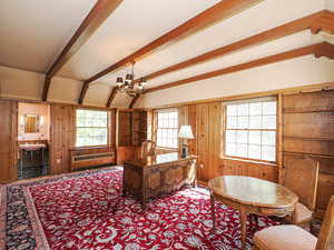 Home office with beamed ceiling, wooden walls, a chandelier, and baseboard heating