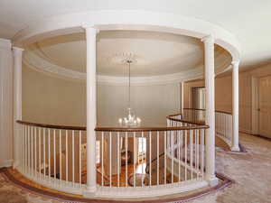 Hallway with decorative columns and a chandelier