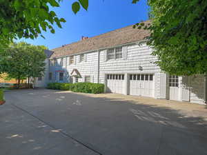 View of front of property featuring a chimney and concrete driveway