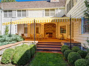 Back of property featuring covered porch and stone siding