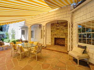 View of patio / terrace with outdoor dining area and an outdoor stone fireplace