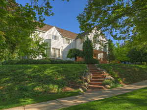 View of front facade featuring stairway and a front yard