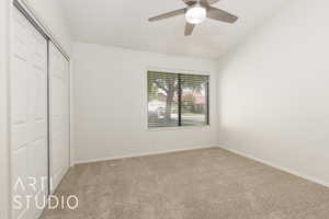 Unfurnished bedroom with a closet, carpet floors, vaulted ceiling, and ceiling fan