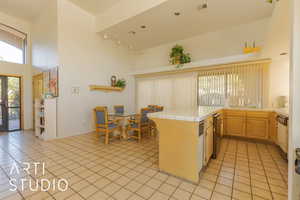 Kitchen featuring tile counters, light brown cabinets, rail lighting, light tile patterned floors, and a peninsula