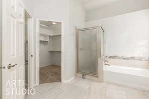 Full bath with a garden tub, a shower stall, a walk in closet, and light tile patterned flooring
