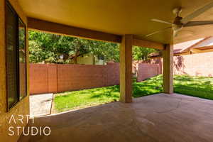 Fenced backyard with a patio and a ceiling fan