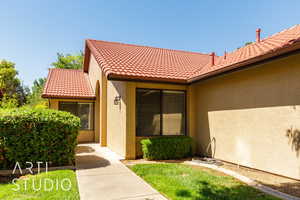 Doorway to property with stucco siding and a tiled roof