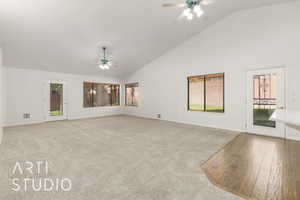 Unfurnished living room featuring high vaulted ceiling, light carpet, and a ceiling fan