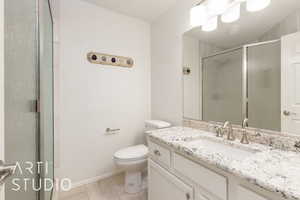 Full bath featuring vanity, a stall shower, and light tile patterned flooring