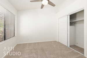 Unfurnished bedroom with carpet, a closet, a ceiling fan, and vaulted ceiling