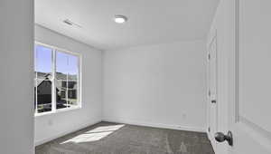 Unfurnished room with carpet and a textured ceiling