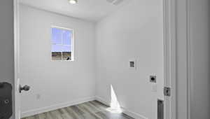Washroom featuring light wood-style flooring and hookup for an electric dryer