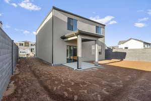 Back of house with a patio area, a fenced backyard, and stucco siding
