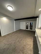Unfurnished living room featuring dark carpet, french doors, and recessed lighting