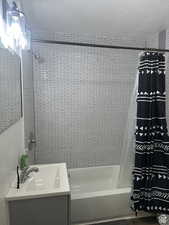 Full bath with shower / tub combo, vanity, and a textured ceiling