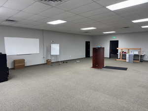Carpeted spare room featuring a paneled ceiling