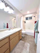 Full bathroom with shower / bath combo with shower curtain, vanity, and light tile patterned floors