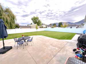 Fenced backyard with new cement patio area, mountain views, and outdoor dining area
