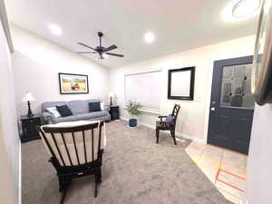 Living area featuring vaulted ceiling, light colored carpet, recessed lighting, ceiling fan, and light tile patterned floors