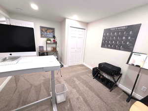Home office with light colored carpet and baseboards