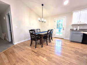 Dining room featuring lofted ceiling, light wood-style floors, a chandelier, and recessed lighting