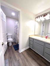 Bathroom featuring dark wood-style flooring, vanity, and a shower with curtain