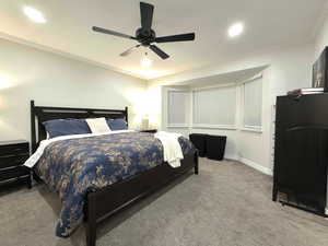 Carpeted bedroom with crown molding, a ceiling fan, and recessed lighting