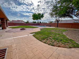 Fenced backyard featuring a patio and a fire pit