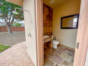 exterior pool bathroomng vanity and stone tile flooring