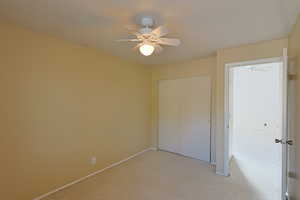 Unfurnished bedroom featuring carpet, a closet, and ceiling fan