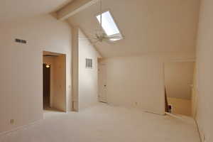 Additional living space with a skylight, beam ceiling, high vaulted ceiling, carpet flooring, and ceiling fan