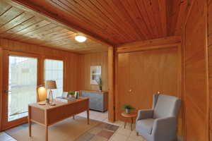 Virtually staged tiled office space featuring wood walls and wooden ceiling