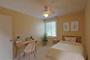 Bedroom with light colored carpet, a textured ceiling, and ceiling fan