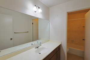 Bathroom featuring vanity, light tile patterned floors, and washtub / shower combination