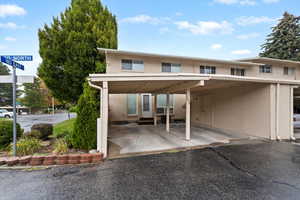 Rear view of property featuring brick siding, a patio, and an attached carport