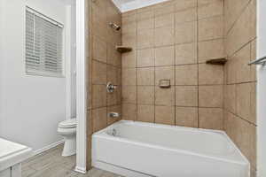 Full bathroom featuring shower / bath combination and wood finished floors