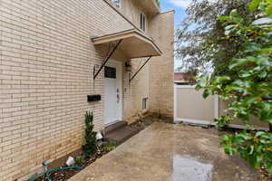 View of exterior entry with brick siding