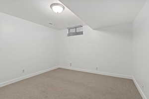 Carpeted spare room with baseboards