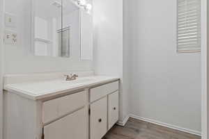 Bathroom with light wood finished floors and vanity