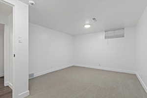 Spare room featuring light colored carpet and a smoke detector