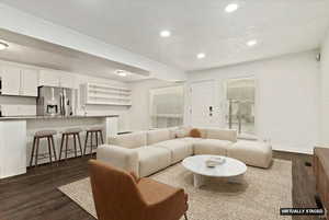 Living area featuring dark wood finished floors and recessed lighting