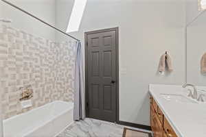 Full bath with shower / tub combo, vanity, and light marble finish floors